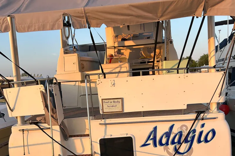Slide: The Image of 1995 Silverton AFT CABIN boat named "Adagio" docked with canopy and deck view. - 3