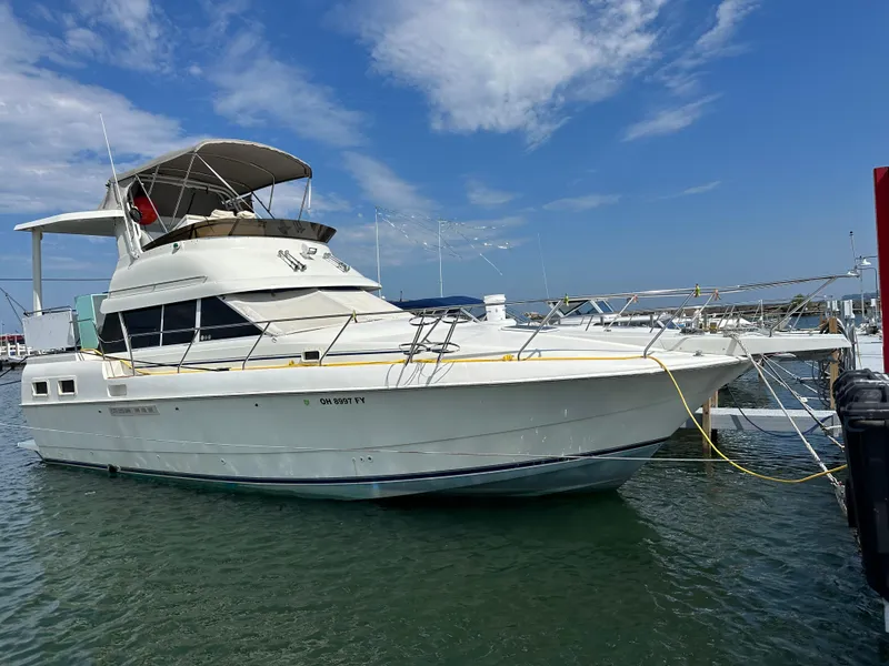 The Image of 1995 Silverton AFT CABIN yacht docked in marina under blue sky. - 0