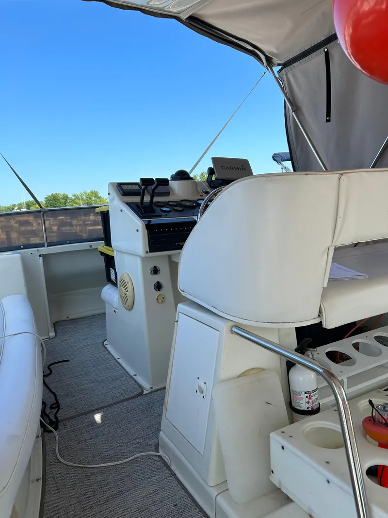 Slide: The Image of 1995 Silverton AFT CABIN boat interior with helm, seating, and equipment under canopy. - 11