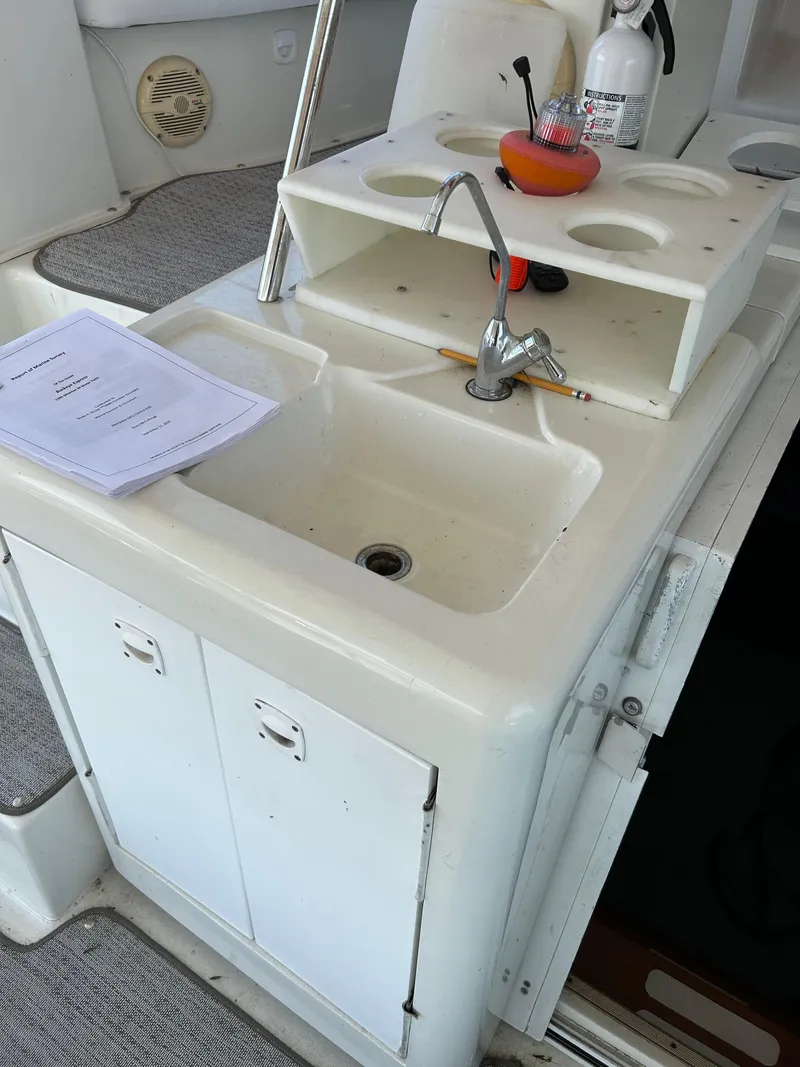 Slide: The Image of 1995 Silverton AFT CABIN boat sink area with faucet and storage. - 12