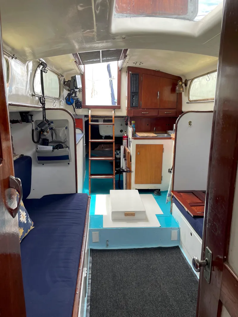Slide: The Image of Interior of a 1960 Rhodes Bounty II sailboat with cozy seating and wooden cabinetry. - 10