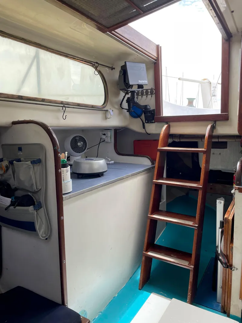 Slide: The Image of Interior of a 1960 Rhodes Bounty II sailboat with wooden ladder and navigation equipment. - 11