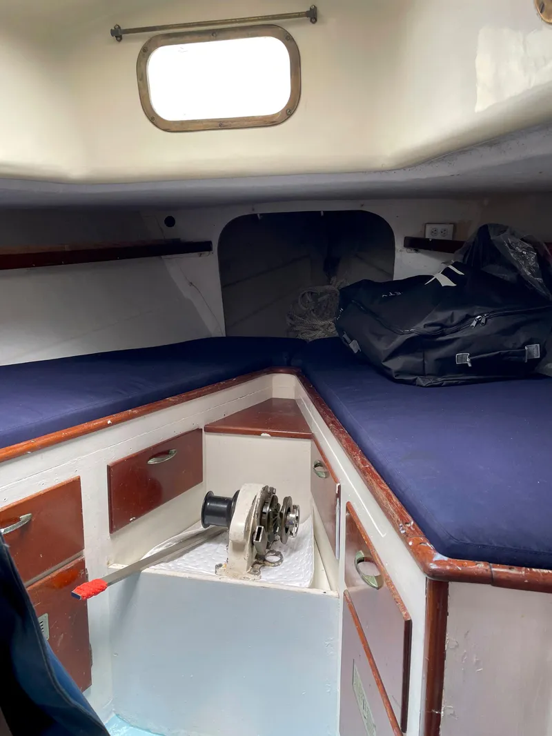 Slide: The Image of Interior cabin of a 1960 Rhodes Bounty II sailboat with blue cushions and wooden cabinetry. - 14