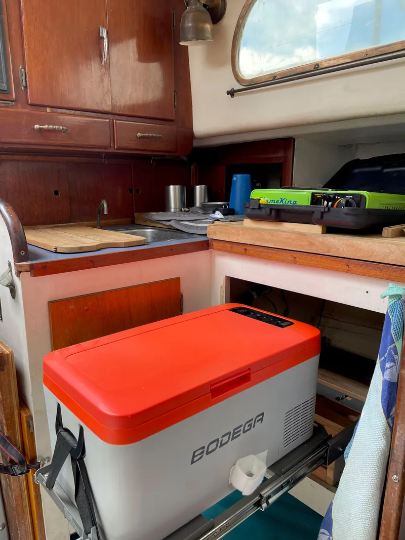 Slide: The Image of Interior of a 1960 Rhodes Bounty II sailboat with a compact kitchen setup. - 15