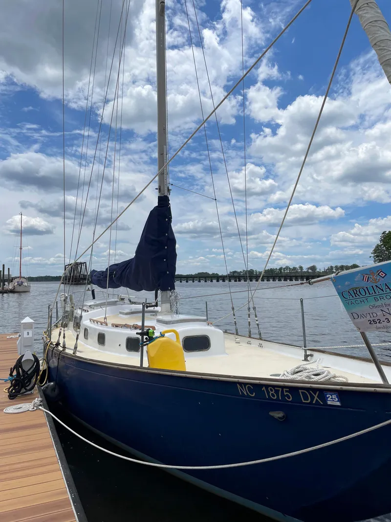 Slide: The Image of 1960 Rhodes Bounty II sailboat docked under a partly cloudy sky. - 17