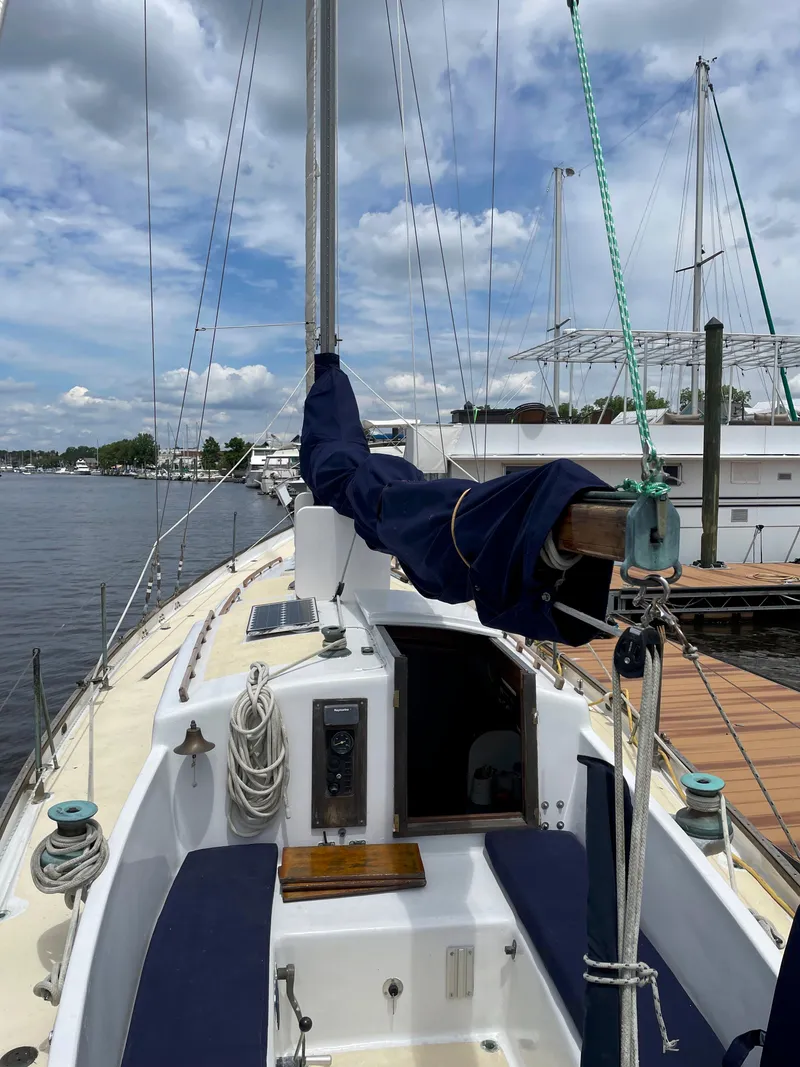 Slide: The Image of 1960 Rhodes Bounty II sailboat docked, featuring a clean deck and blue sail cover. - 18