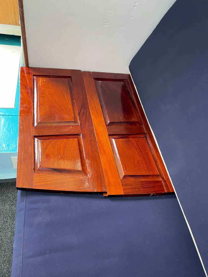 Slide: The Image of Wooden cabinet doors inside a 1960 Rhodes Bounty II boat. - 21