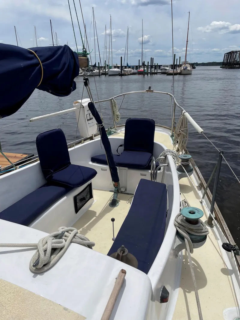 Slide: The Image of 1960 Rhodes Bounty II sailboat with blue seating, docked at a marina. - 22