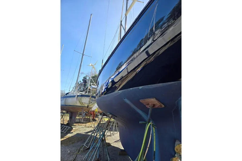 Slide: The Image of Sailboats in dry dock, featuring a 1960 Rhodes Bounty II with a polished hull. - 26