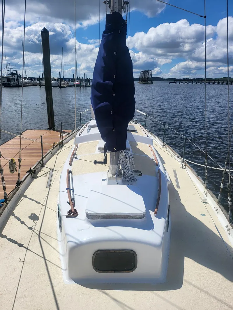 Slide: The Image of 1960 Rhodes Bounty II sailboat docked, featuring a covered mast and clear skies. - 4