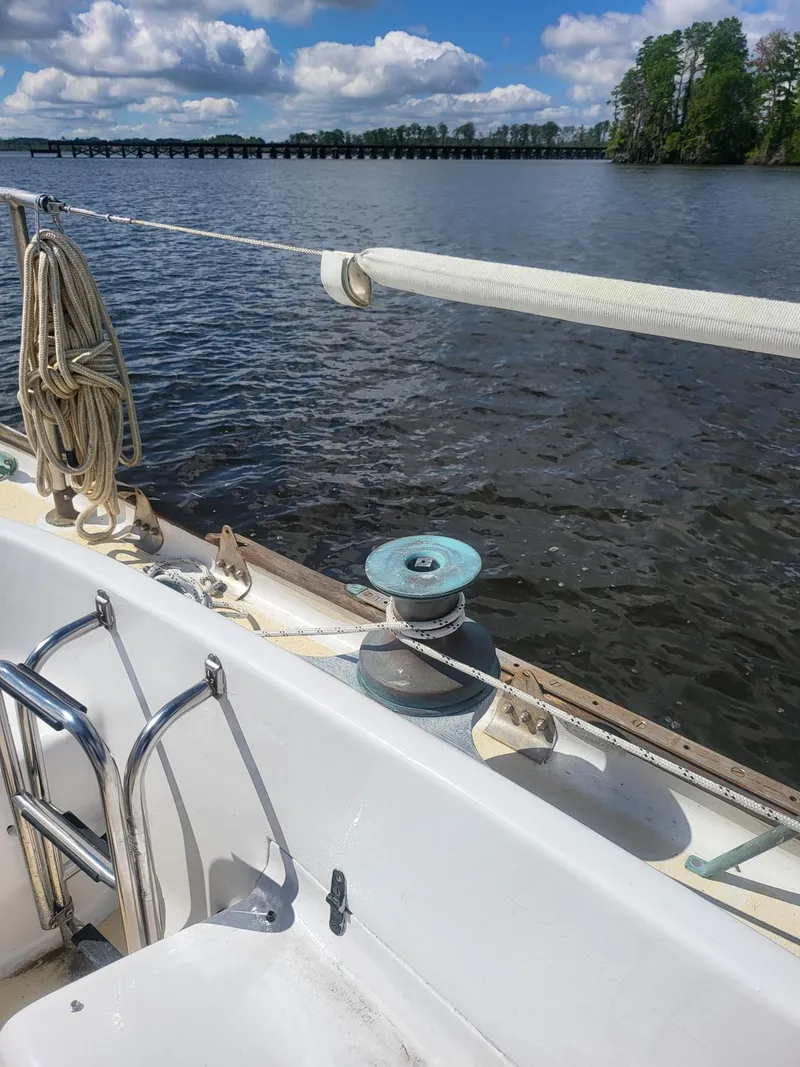 Slide: The Image of 1960 Rhodes Bounty II sailboat on a calm lake with clear skies. - 5