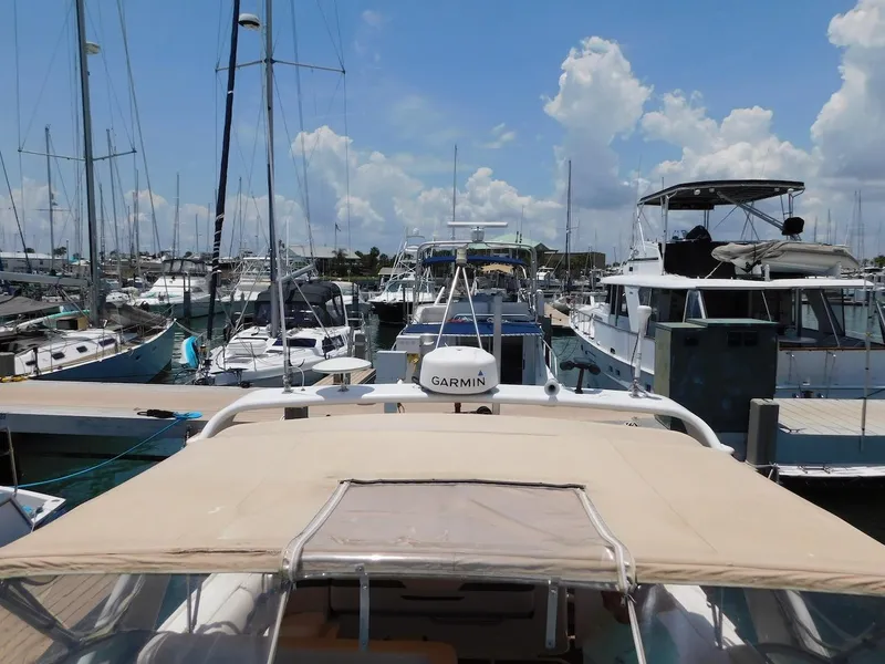 Slide: The Image of 1999 Formula 41 Performance Cruiser docked at a marina with other boats under a clear sky. - 10