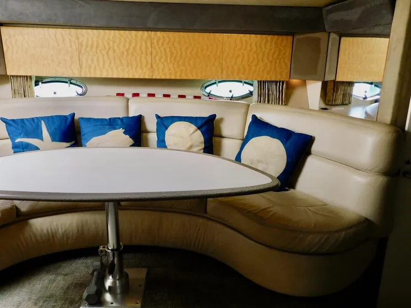 Slide: The Image of 1999 Formula 41 Performance Cruiser interior with curved seating and nautical-themed pillows. - 23