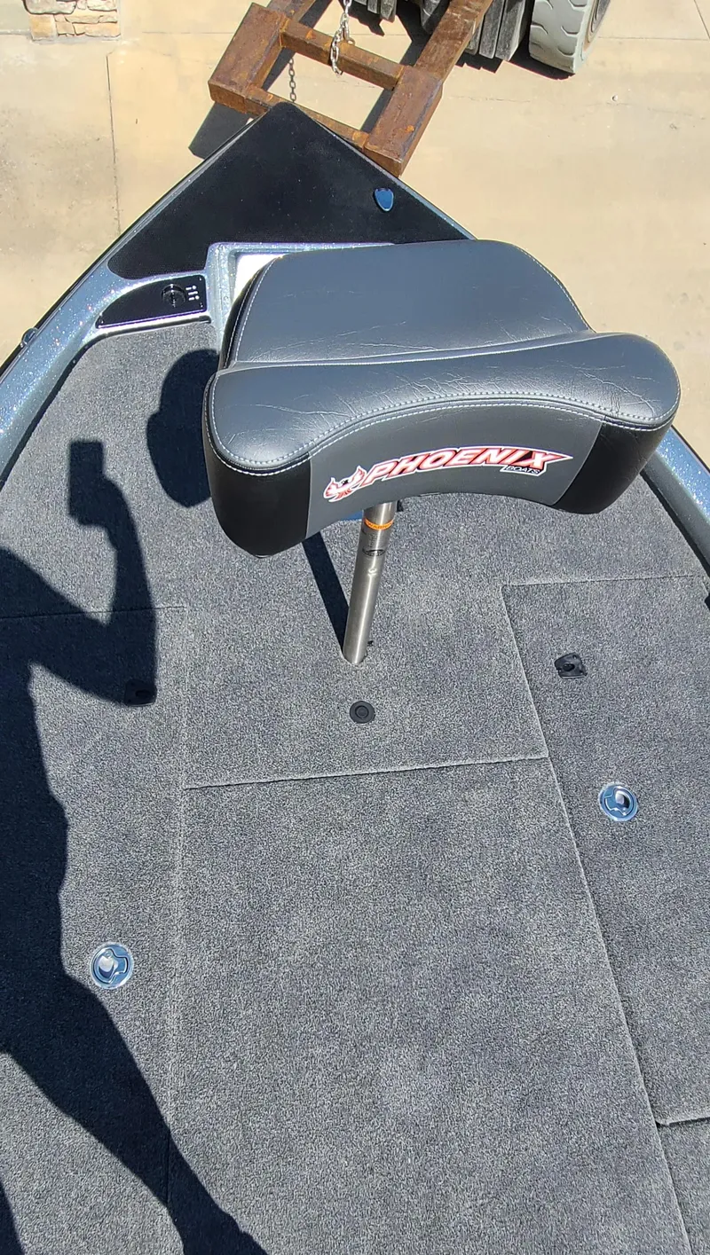 Slide: The Image of 2025 Phoenix 920 Elite 1 boat with cushioned seat and carpeted deck. - 1