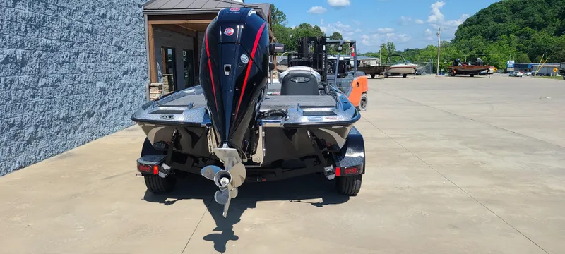 Slide: The Image of 2025 Phoenix 920 Elite 1 boat, rear view, parked outdoors on a sunny day. - 6