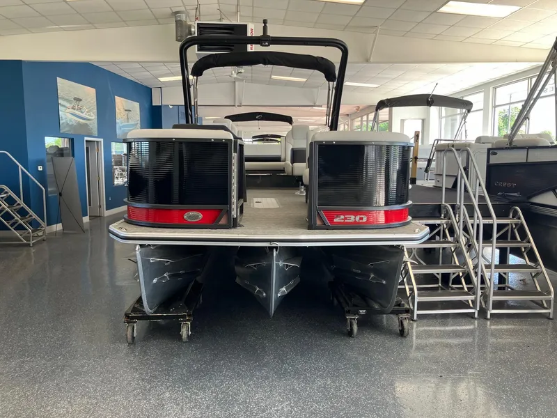Slide: The Image of 2024 Crest Caribbean 230 SLS RS pontoon boat displayed in a showroom. - 2