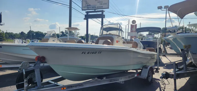 Slide: The Image of 2022 Pioneer 180 Islander boat on a trailer in a dealership lot. - 2