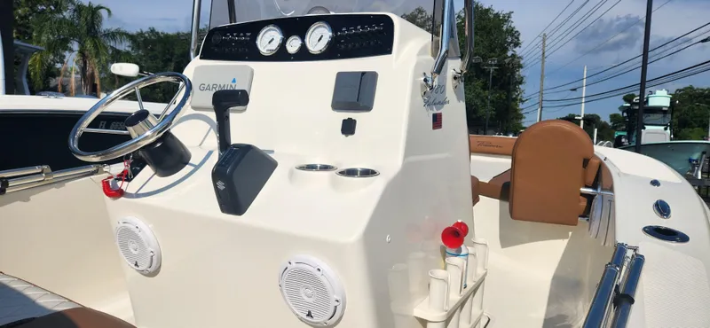 Slide: The Image of 2022 Pioneer 180 Islander boat console with steering wheel, gauges, and Garmin electronics. - 6