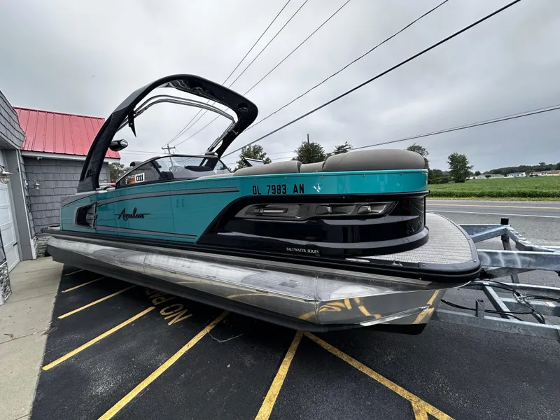 Slide: The Image of 2021 Avalon Excalibur 2585 Tri Toon boat with high performance, teal and black design. - 10