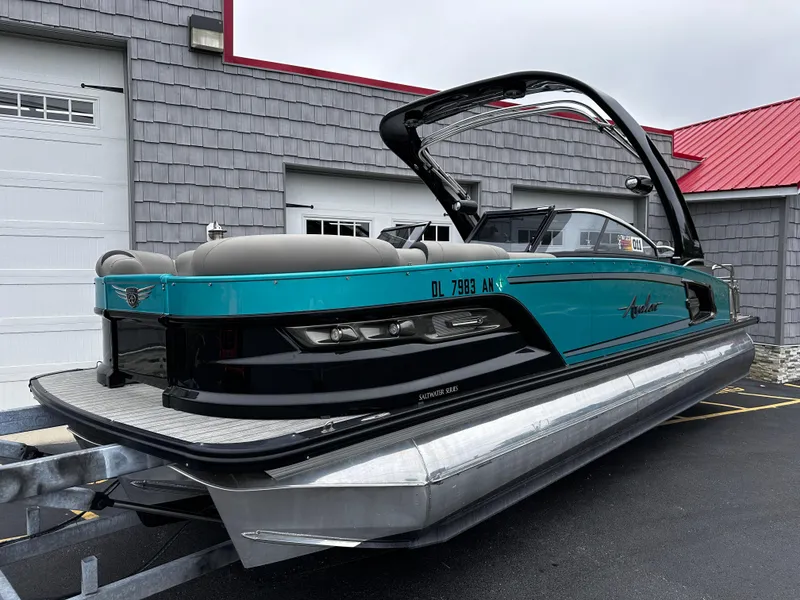 Slide: The Image of 2021 Avalon Excalibur 2585 Tri Toon boat with high performance, teal and black design. - 2