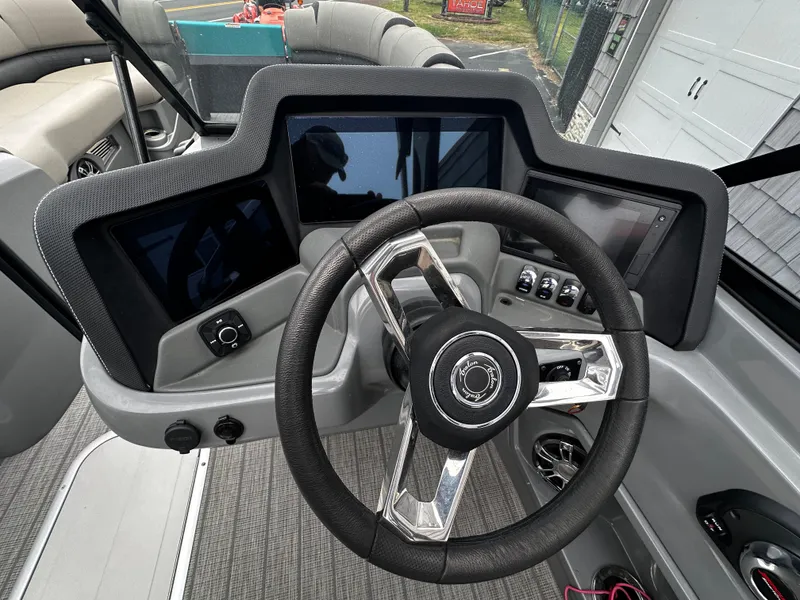 Slide: The Image of 2021 Avalon Excalibur 2585 boat dashboard with modern steering wheel and digital displays. - 21