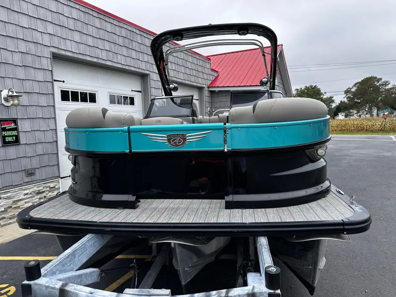 Slide: The Image of 2021 Avalon Excalibur 2585 Tri Toon boat with windshield, parked on trailer. - 4