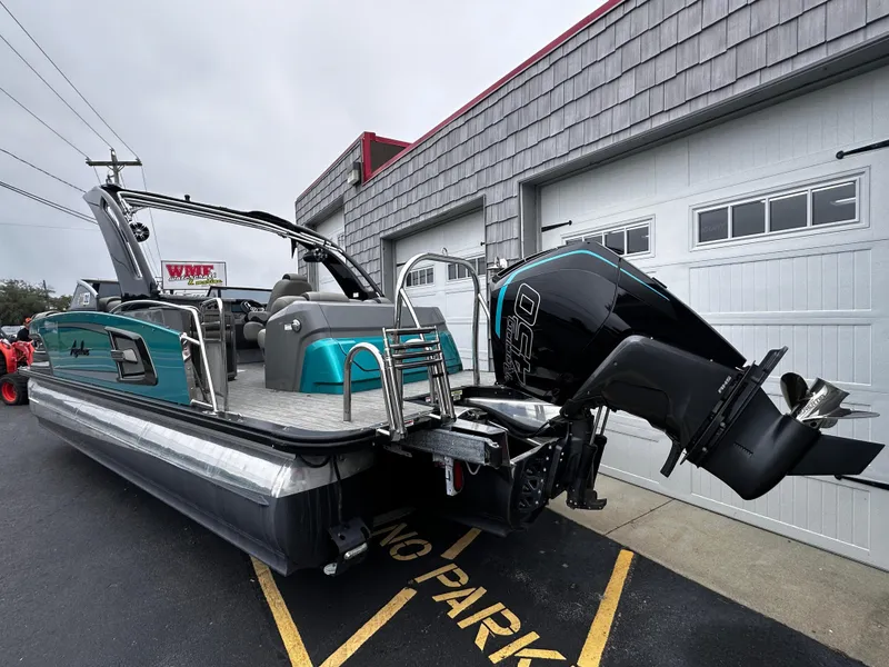 Slide: The Image of 2021 Avalon Excalibur 2585 Tri Toon boat with 450R engine, parked outside a garage. - 5