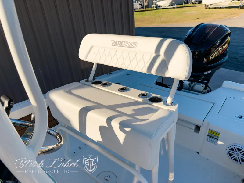 Slide: The Image of 2024 Pathfinder TRS 2200 boat seat with rod holders and engine in background. - 17
