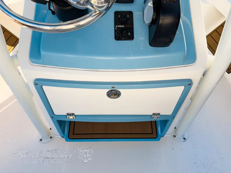 Slide: The Image of 2024 Pathfinder TRS 2200 boat console with steering wheel and storage compartment. - 19