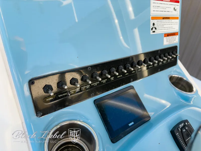Slide: The Image of Control panel of 2024 Pathfinder TRS 2200 boat with switches and display screen. - 21