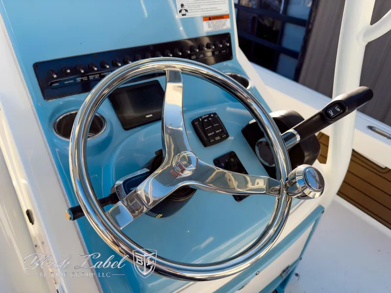 Slide: The Image of Steering console of 2024 Pathfinder TRS 2200 boat with chrome wheel and controls. - 23