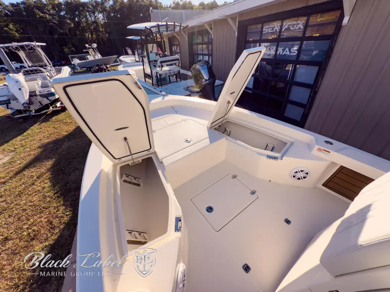 Slide: The Image of 2024 Pathfinder TRS 2200 boat with open storage compartments, displayed outdoors. - 8