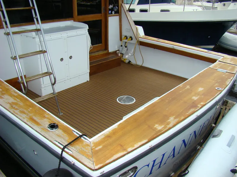 Slide: The Image of 1985 Jersey Dawn 40 boat deck with wooden flooring and storage cabinet. - 14