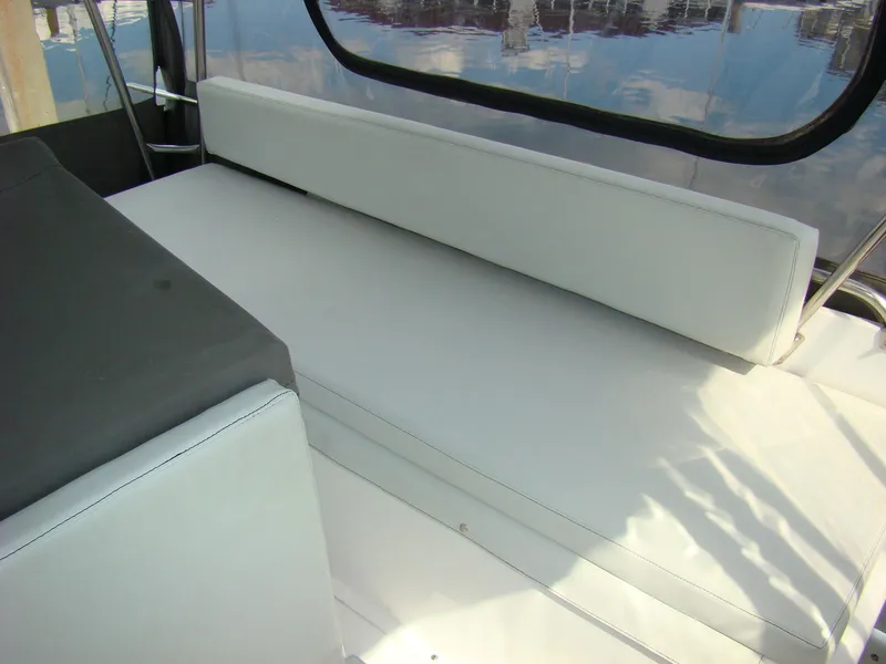Slide: The Image of 1985 Jersey Dawn 40 boat interior seating area with white cushions. - 30
