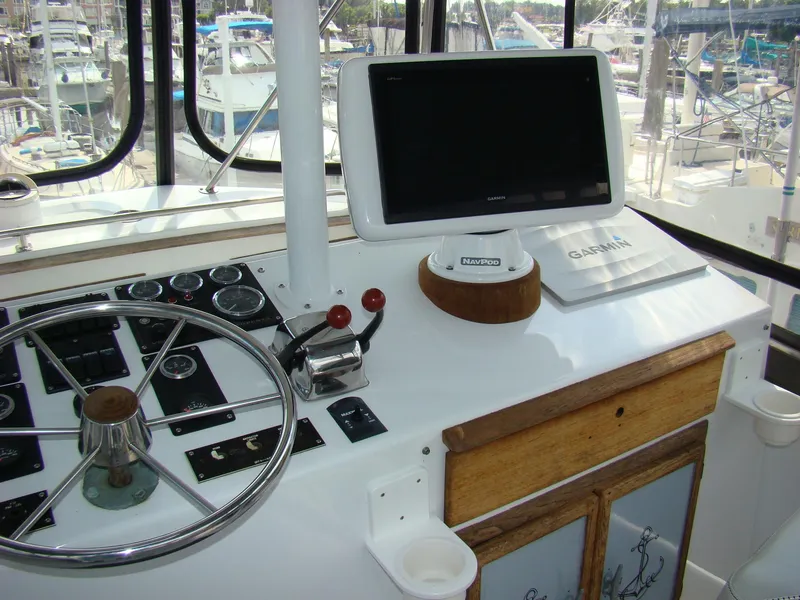 Slide: The Image of Control panel of a 1985 Jersey Dawn 40 boat with steering wheel and Garmin GPS. - 32