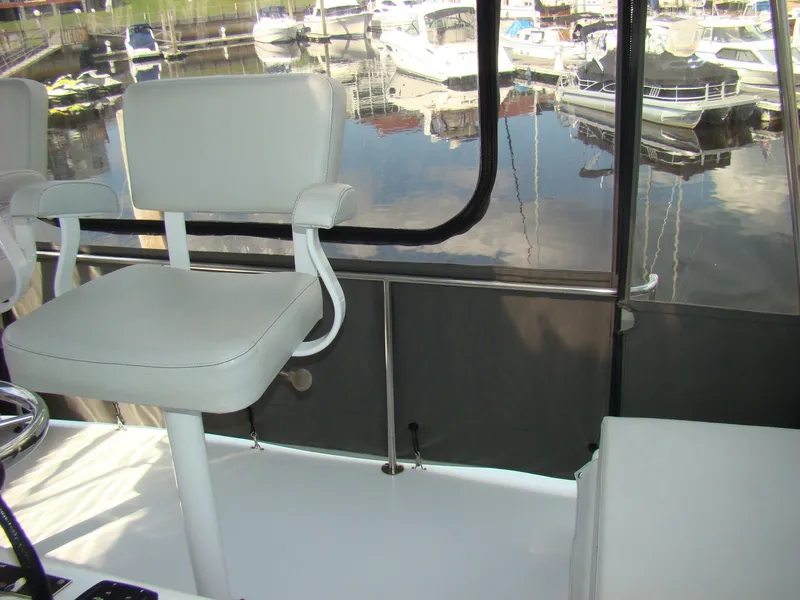 Slide: The Image of Interior of 1985 Jersey Dawn 40 boat with white seating and marina view. - 34