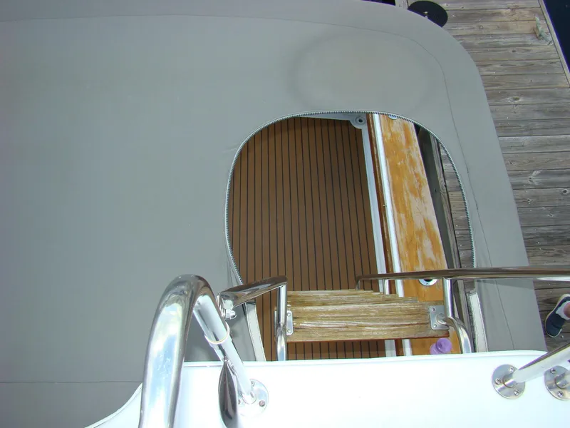 Slide: The Image of 1985 Jersey Dawn 40 boat with covered deck and wooden steps. - 35