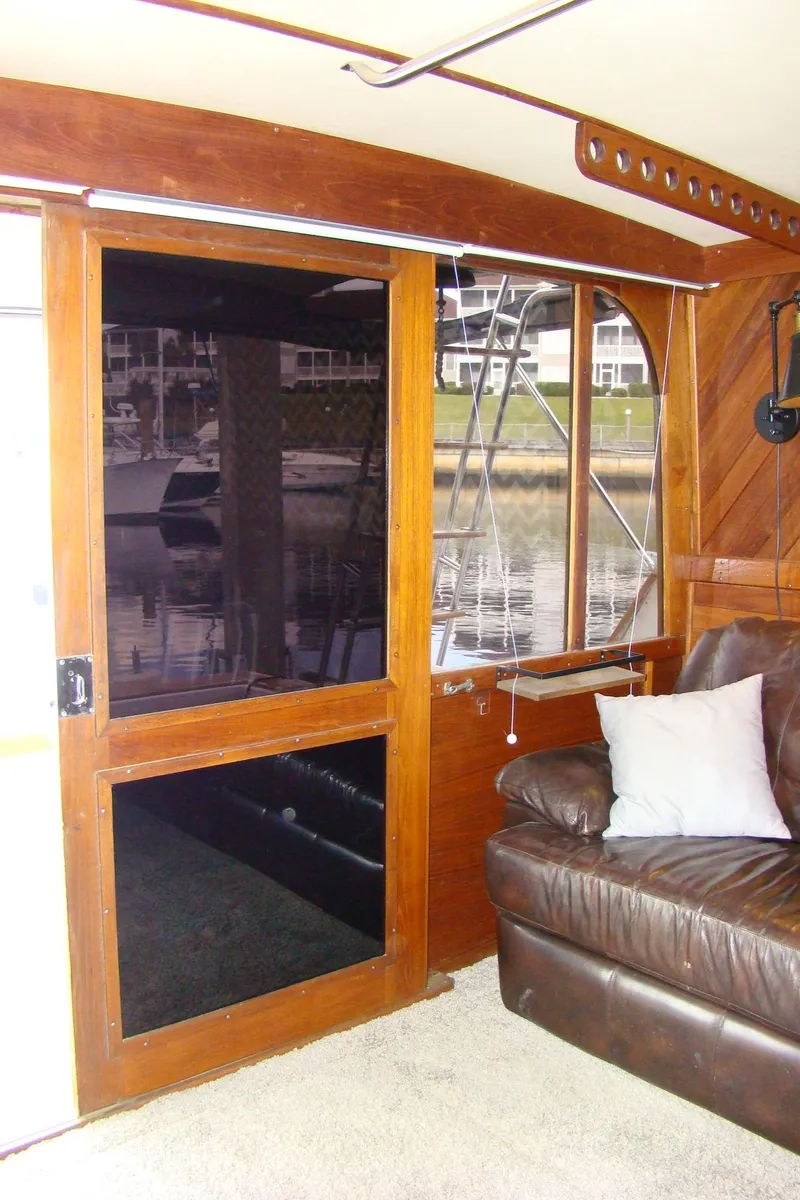 Slide: The Image of Interior of 1985 Jersey Dawn 40 boat with leather seating and wooden door. - 40