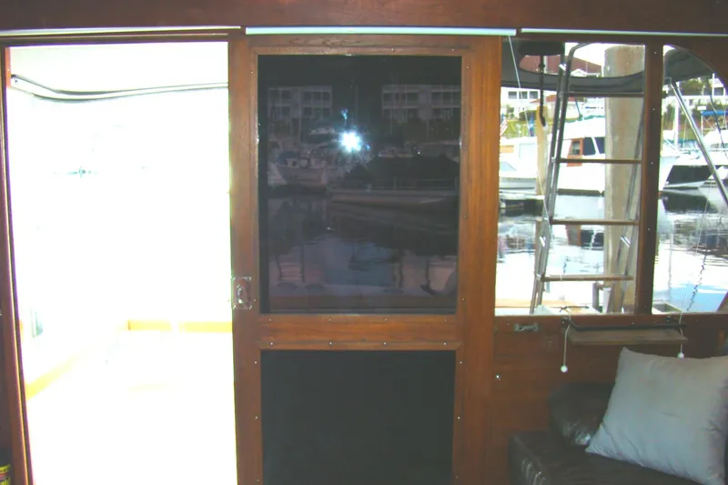 Slide: The Image of Interior view of 1985 Jersey Dawn 40 boat with wooden door and marina background. - 42