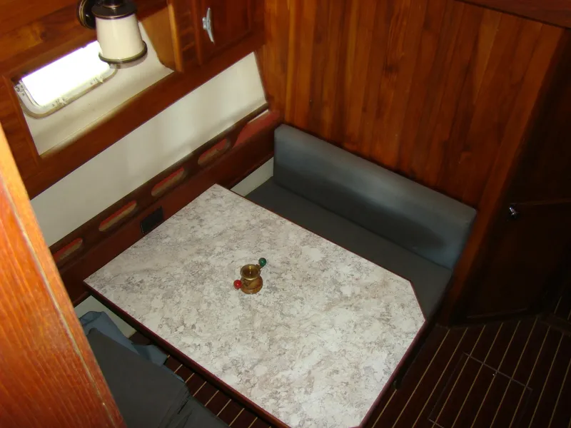 Slide: The Image of 1985 Jersey Dawn 40 boat interior with wooden paneling and dining area. - 43