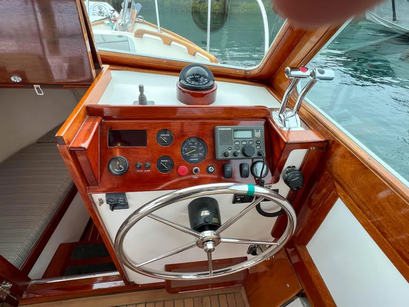 Slide: The Image of 2004 Custom Pemaquid Beach 22 boat helm with wooden dashboard and steering wheel. - 15