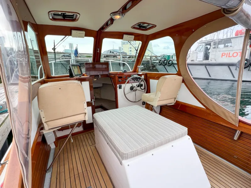 Slide: The Image of Interior of 2004 Custom Pemaquid Beach 22 boat with wooden accents and beige seating. - 20