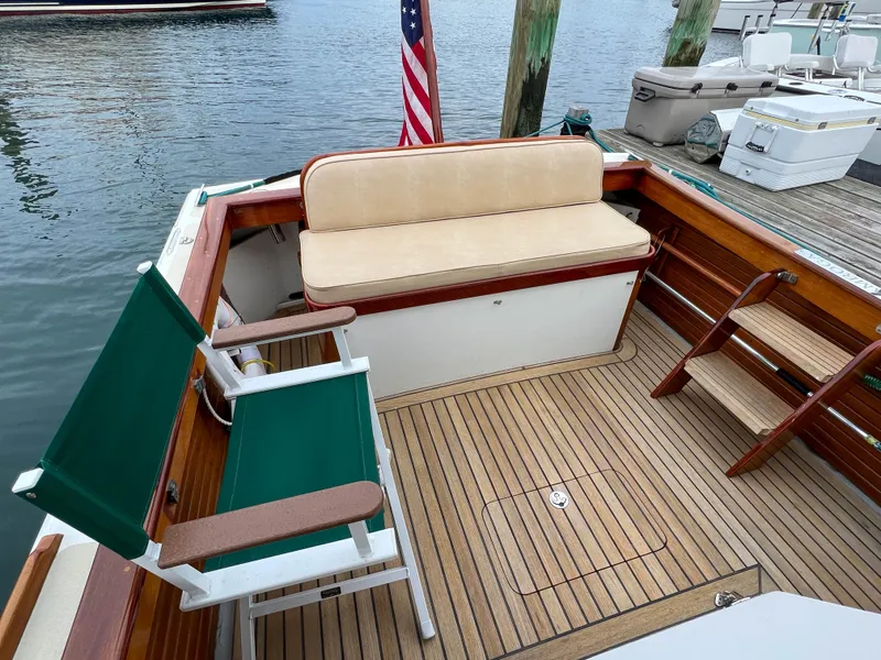 Slide: The Image of 2004 Custom Pemaquid Beach 22 boat with teak deck and green chairs at dock. - 22