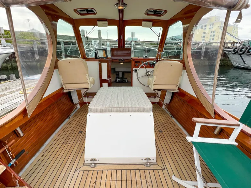 Slide: The Image of Interior of a 2004 Custom Pemaquid Beach 22 boat with wooden flooring and seating. - 23