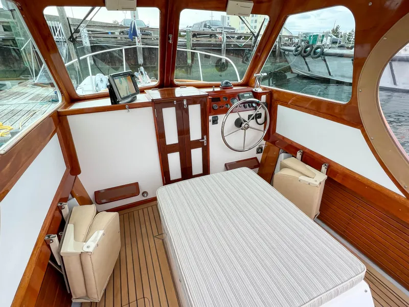 Slide: The Image of Custom 2004 Pemaquid Beach 22 boat interior with wooden finish and steering wheel. - 25