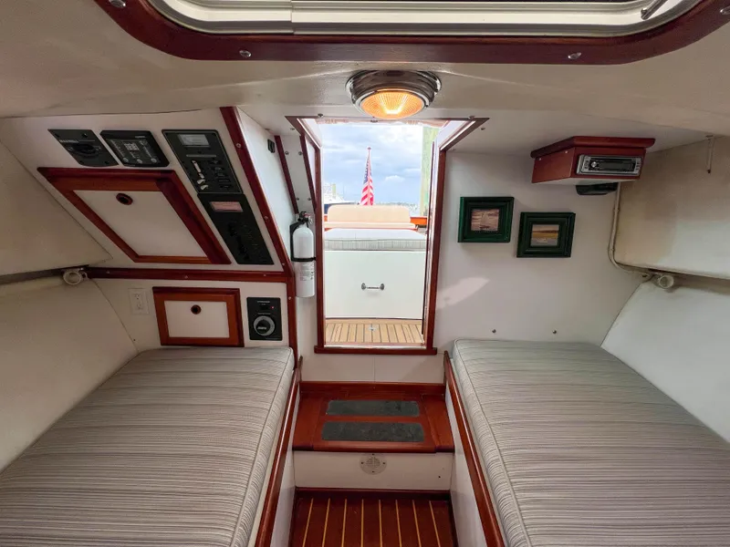 Slide: The Image of Interior cabin of 2004 Custom Pemaquid Beach 22 boat with twin beds and control panels. - 6