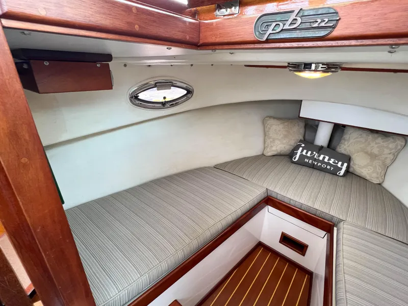 Slide: The Image of Cozy cabin interior of a 2004 Custom Pemaquid Beach 22 boat with striped cushions. - 8