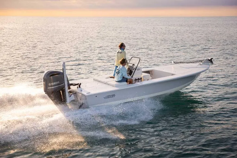 Slide: The Image of 2025 Hewes 21 REDFISHER boat cruising on open water at sunset. - 0