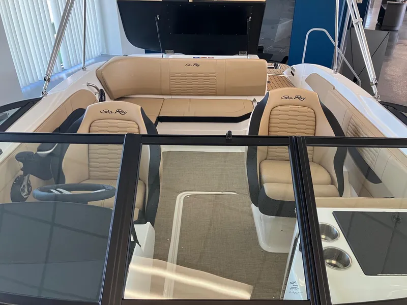 Slide: The Image of 2024 Sea Ray SPX 210 boat interior with beige seating and black accents. - 10