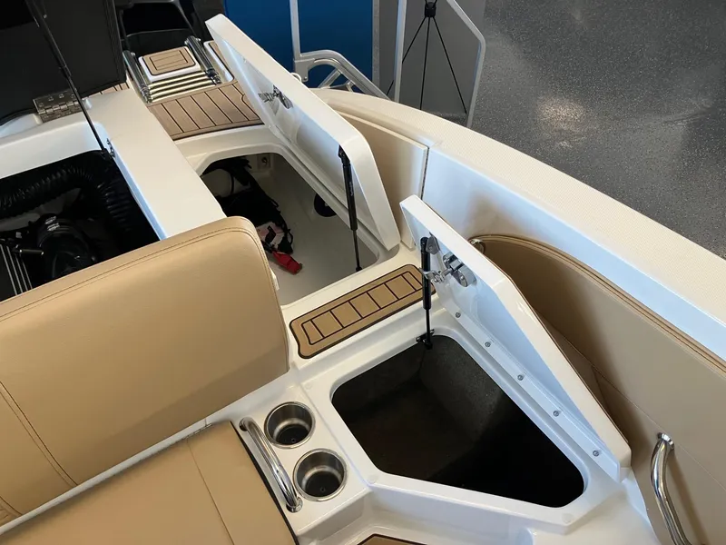 Slide: The Image of 2024 Sea Ray SPX 210 boat interior with open storage compartments and cup holders. - 13